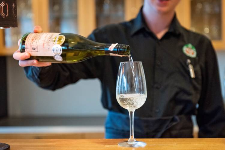 Person som häller upp vin i glas 750x500.jpg